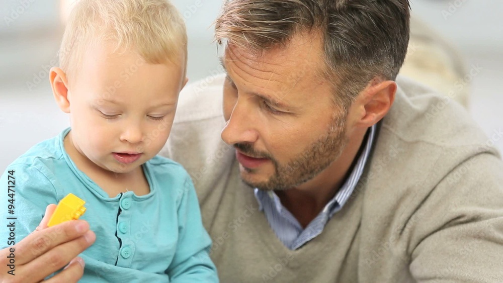 Daddy with baby boy playing with blocks on the floor Daddy with baby boy playing with blocks on the floor