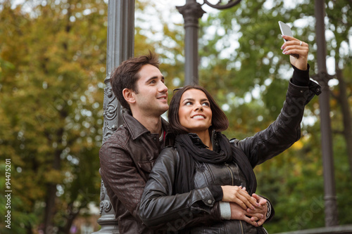 Smiling couple making selfie photo on smartphone