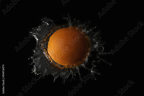 Orange in the water on black background