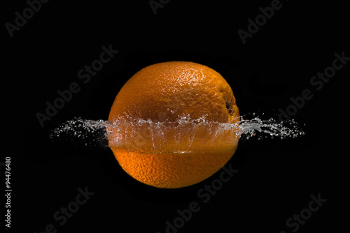 Orange in the water on black background