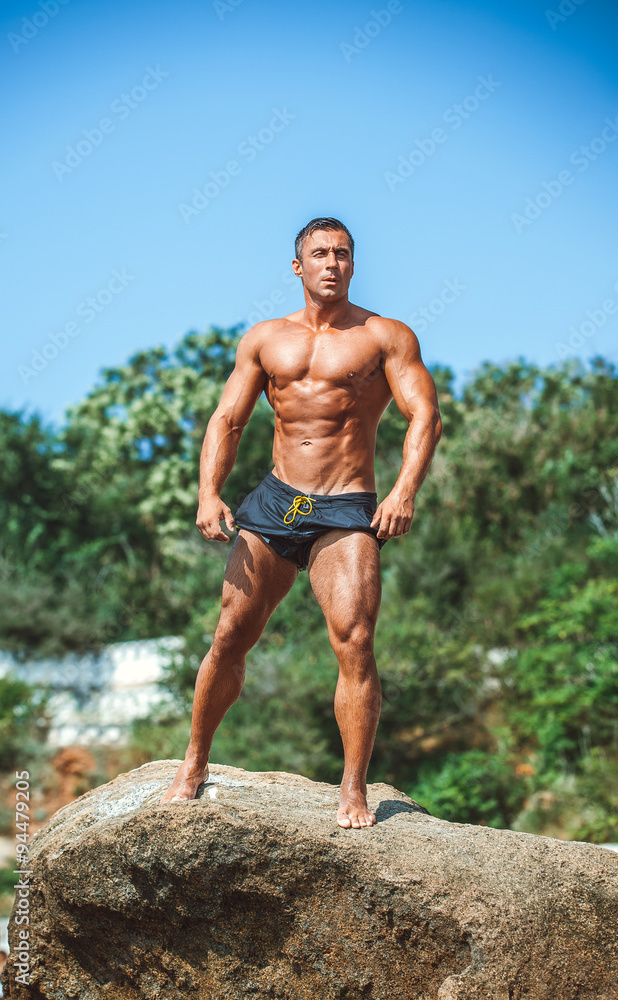 Man Athlete on a rock by the sea against the sky