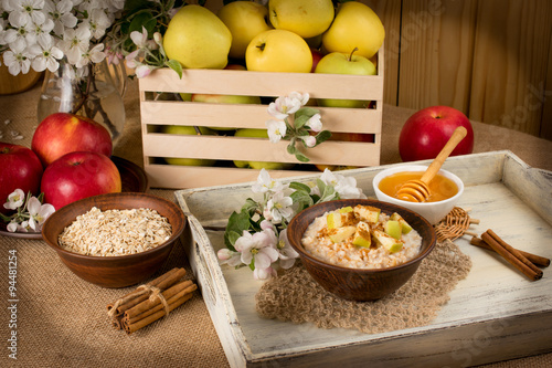 Oatmeal with apple and cinnamon in the bowl  honey and cinnamon