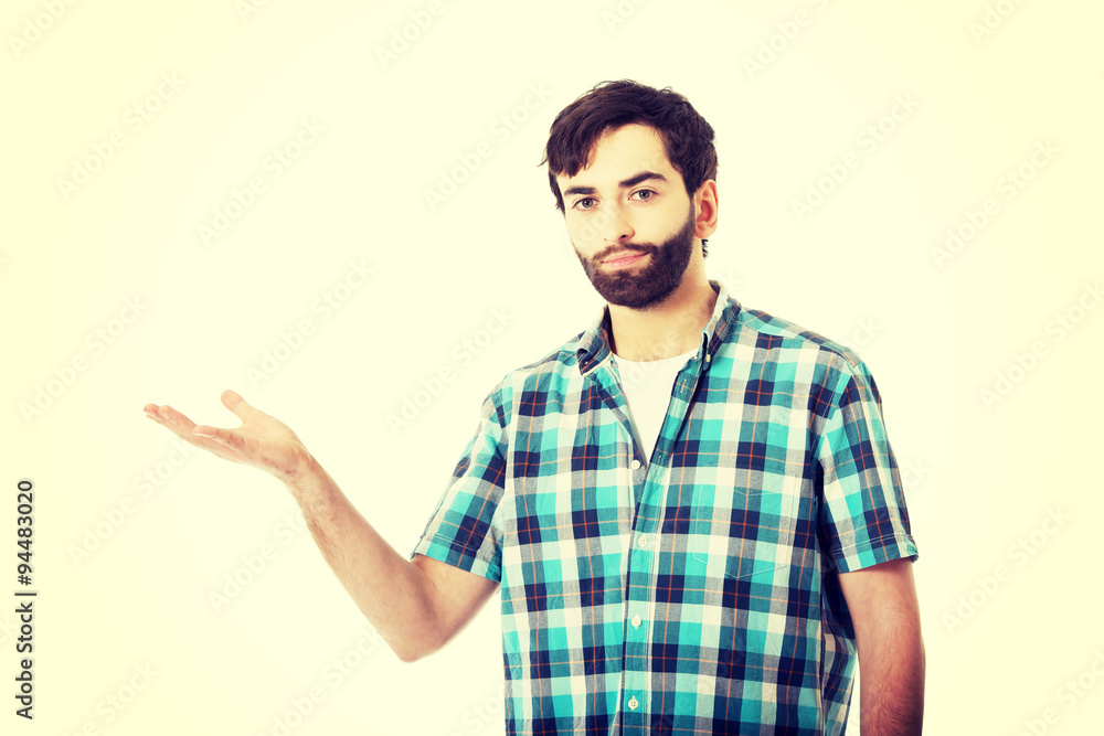 Young man showing something on palm. Young man showing something on palm.