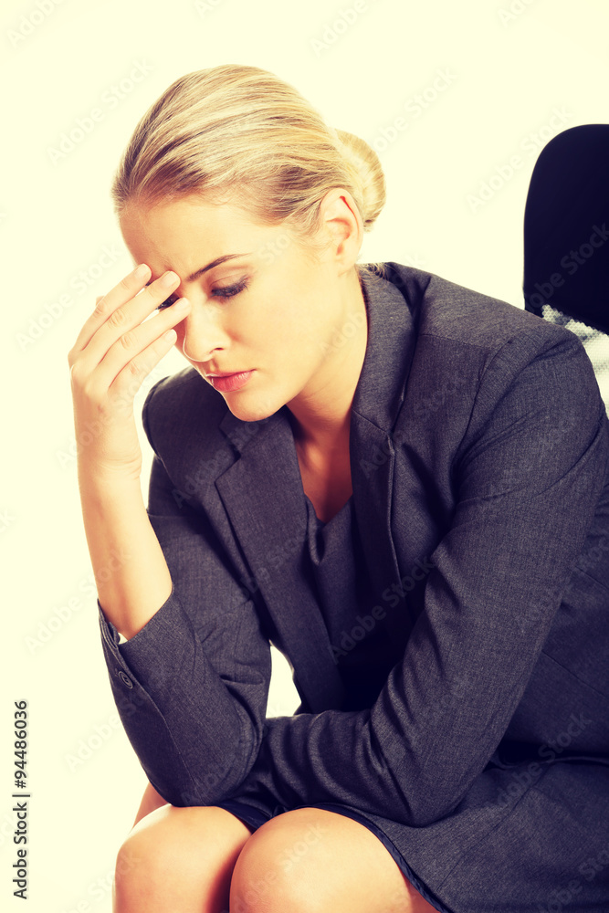 Depressed businesswoman sitting on armchair Depressed businesswoman sitting on armchair