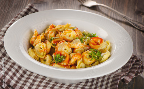Ravioli pasta with tomato sauce and fresh herbs.