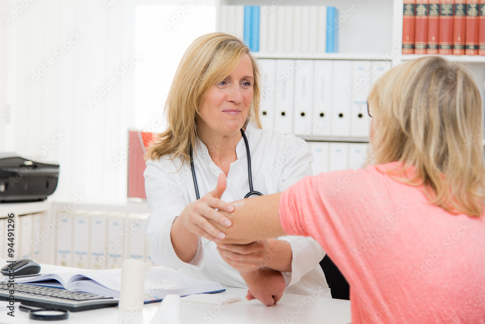 Fototapeta premium ärztin behandelt den arm einer patientin