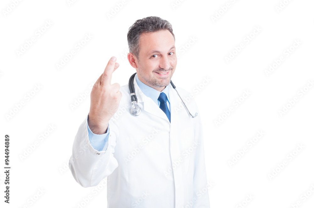 Friendly doctor making good luck gesture with crossed fingers