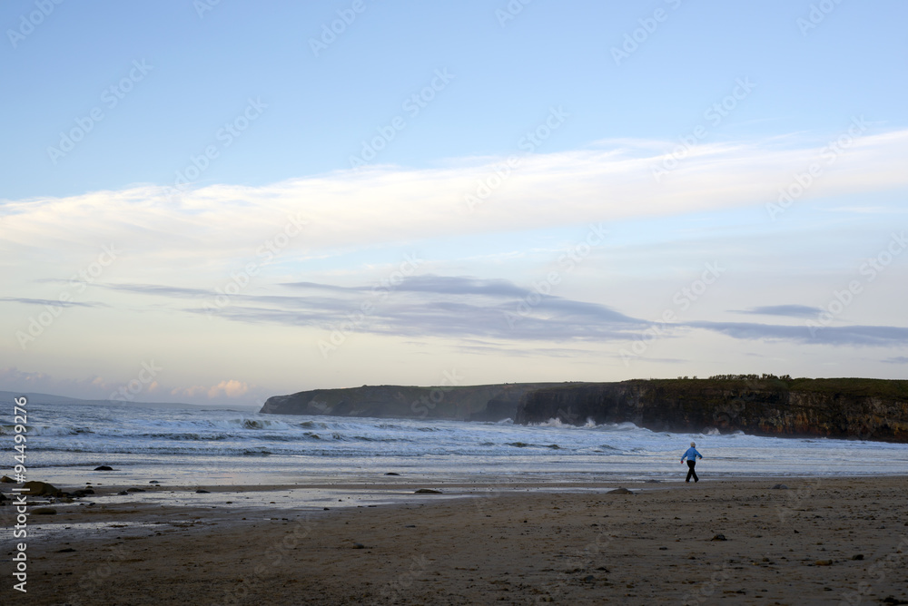 woman walking at rocky cold beach