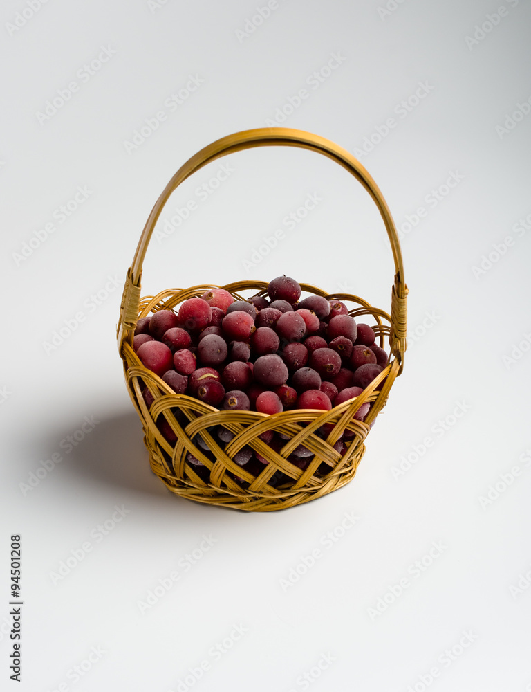 cranberries in a wicker basket on a white background cranberries in a wicker basket on a white background