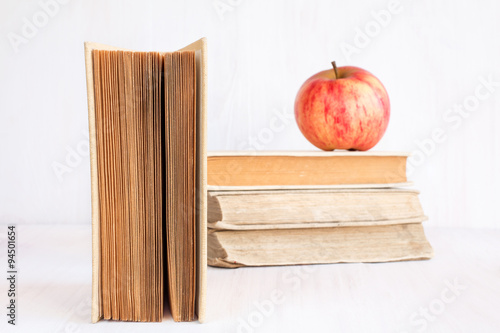 Books and apple on white bookshelf