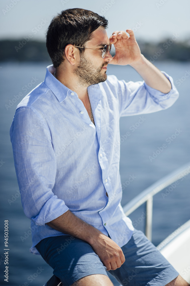 Handsome man on a yacht enjoy bright sun light on vacation Handsome man on a yacht enjoy bright sun light on vacation