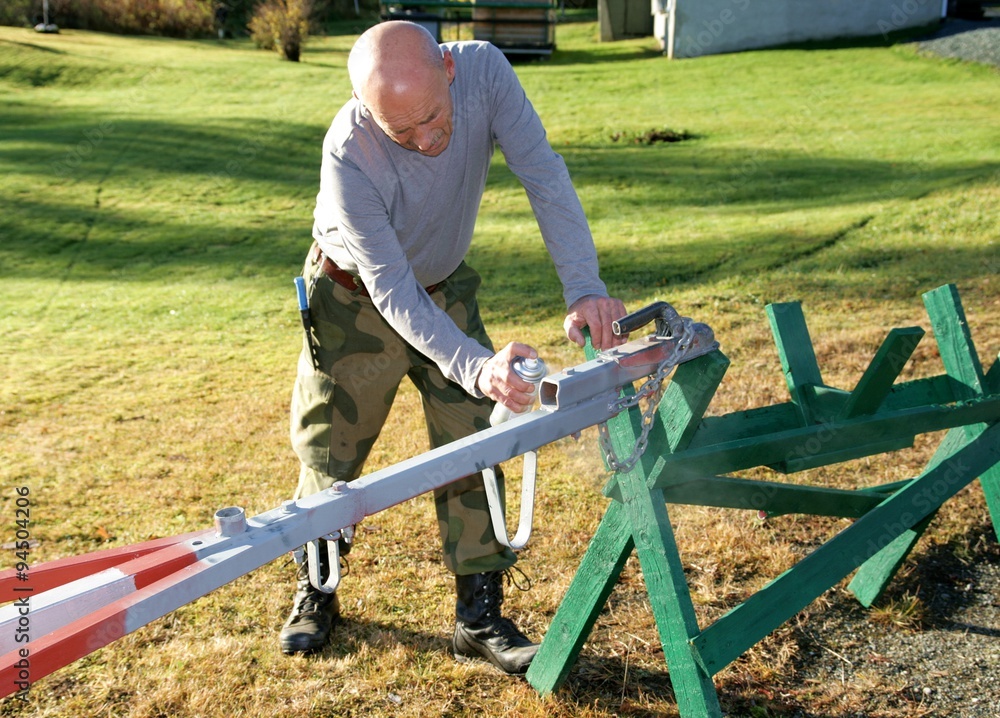 Man painting a tow bar on a trailer