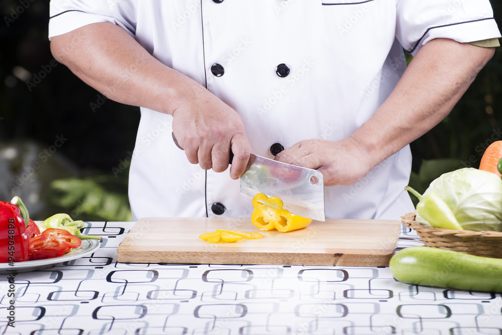 Chef cutting yellow bell pepper
