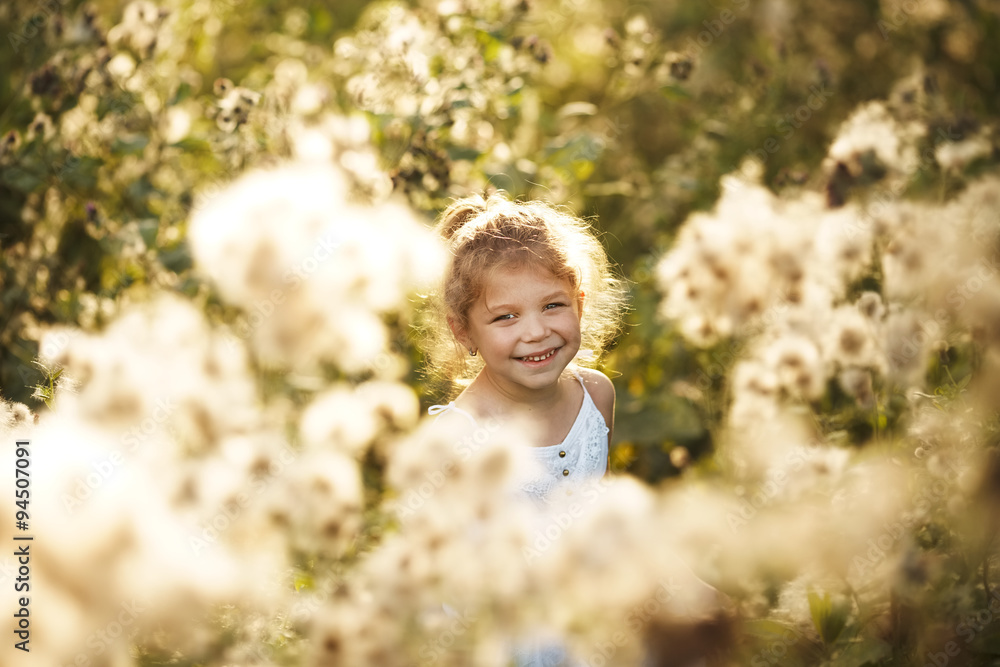 Happy cheerful little girl among wildflowers Happy cheerful little girl among wildflowers