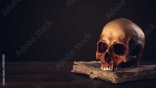 Human skull on an open ancient book