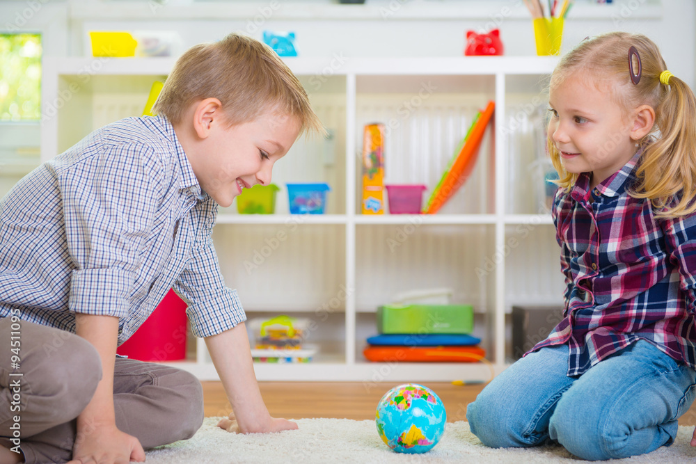 Fototapeta premium Two clever children exploring globe