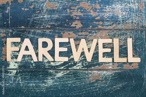 Word farewell written on rustic wooden surface
