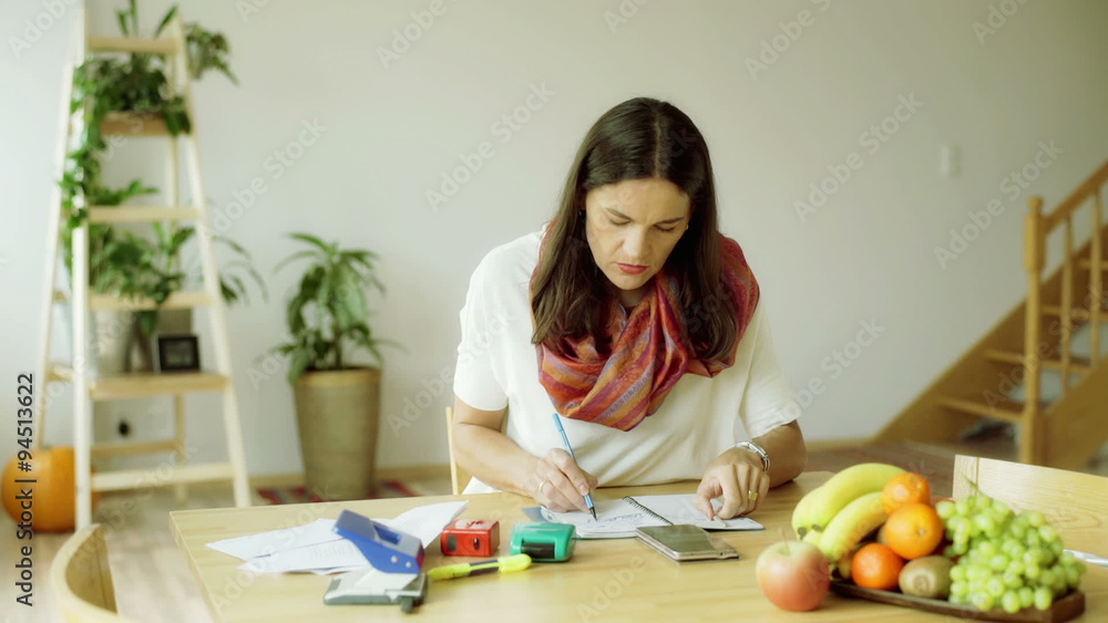 Woman sitting at the table and working on something
Woman sitting at the table and working on something