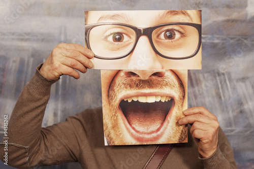 man holding a card with a big smile and big glasses on it