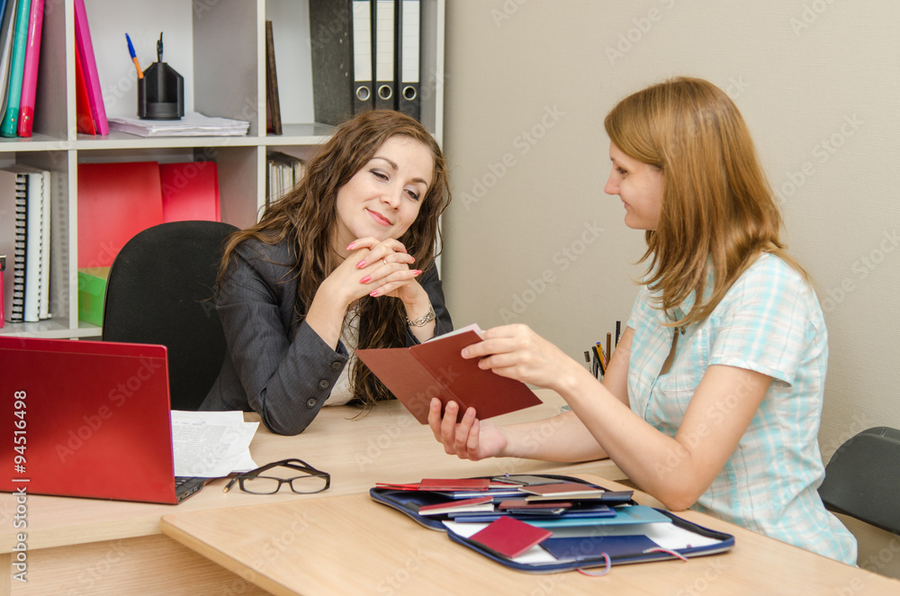Fototapeta premium A young girl shows Diplomas office worker