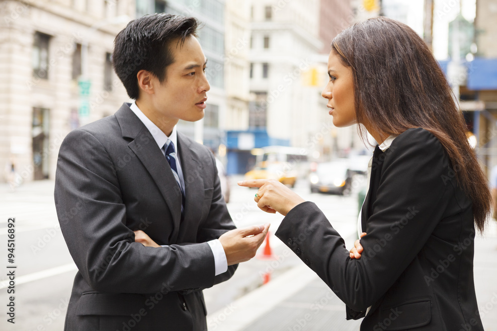 A man and a woman arguing on a city street.