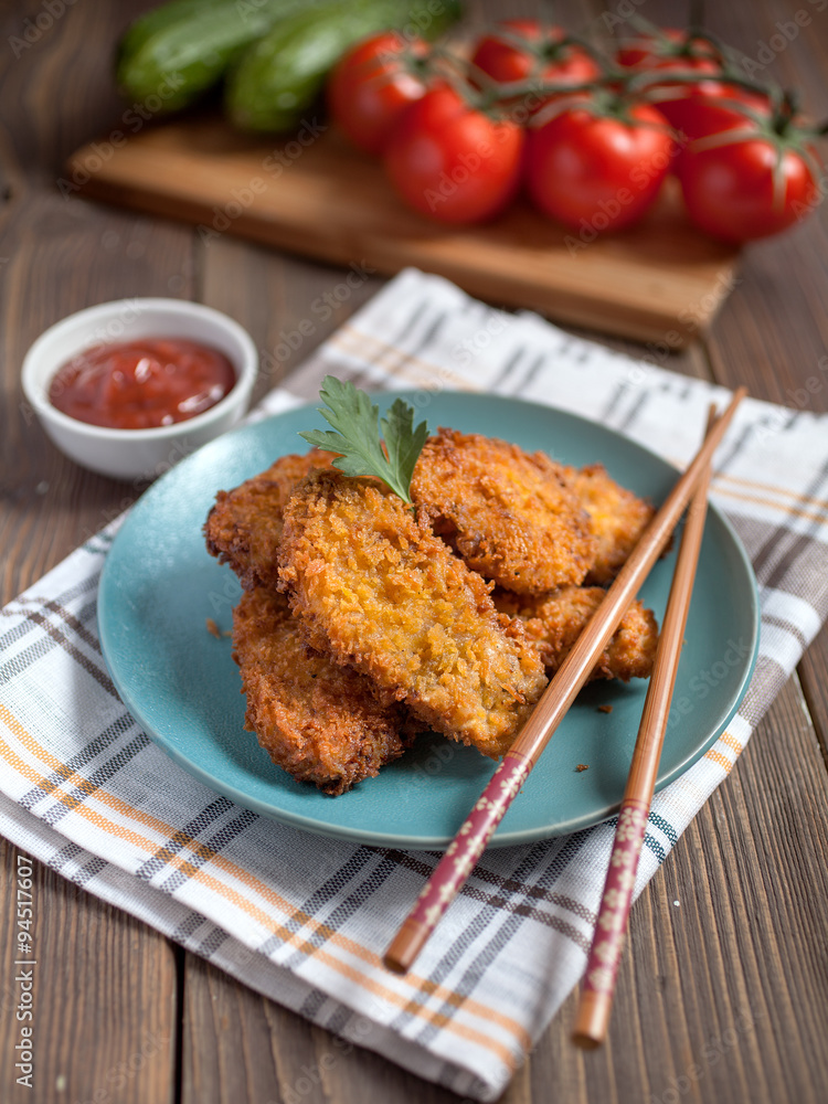chicken fried in breadcrumbs on a blue plate chicken fried in breadcrumbs on a blue plate