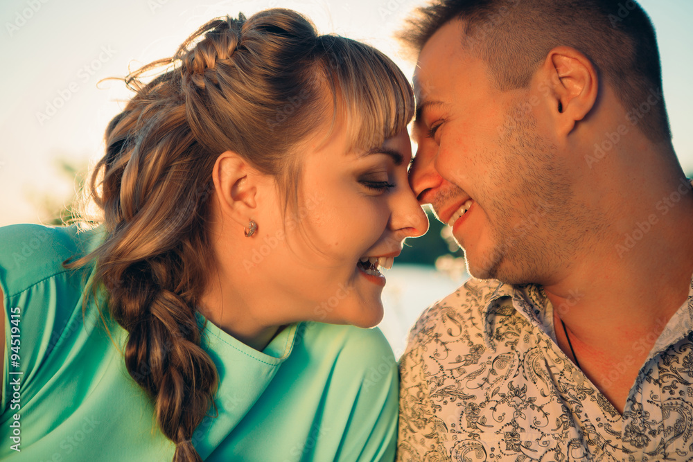 Naklejka premium Romantic couple sit and kissing on background summer lake