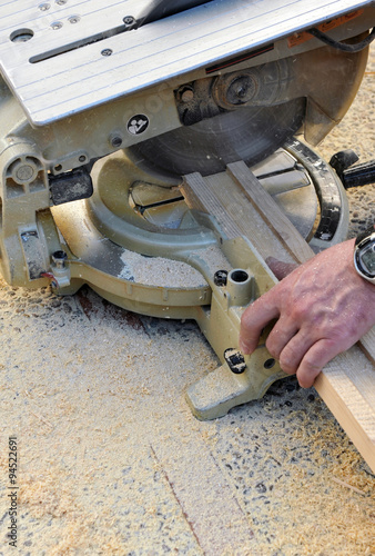 Carpintero cortando un perfil de madera con la sierra de disco, herramienta de carpintería 
