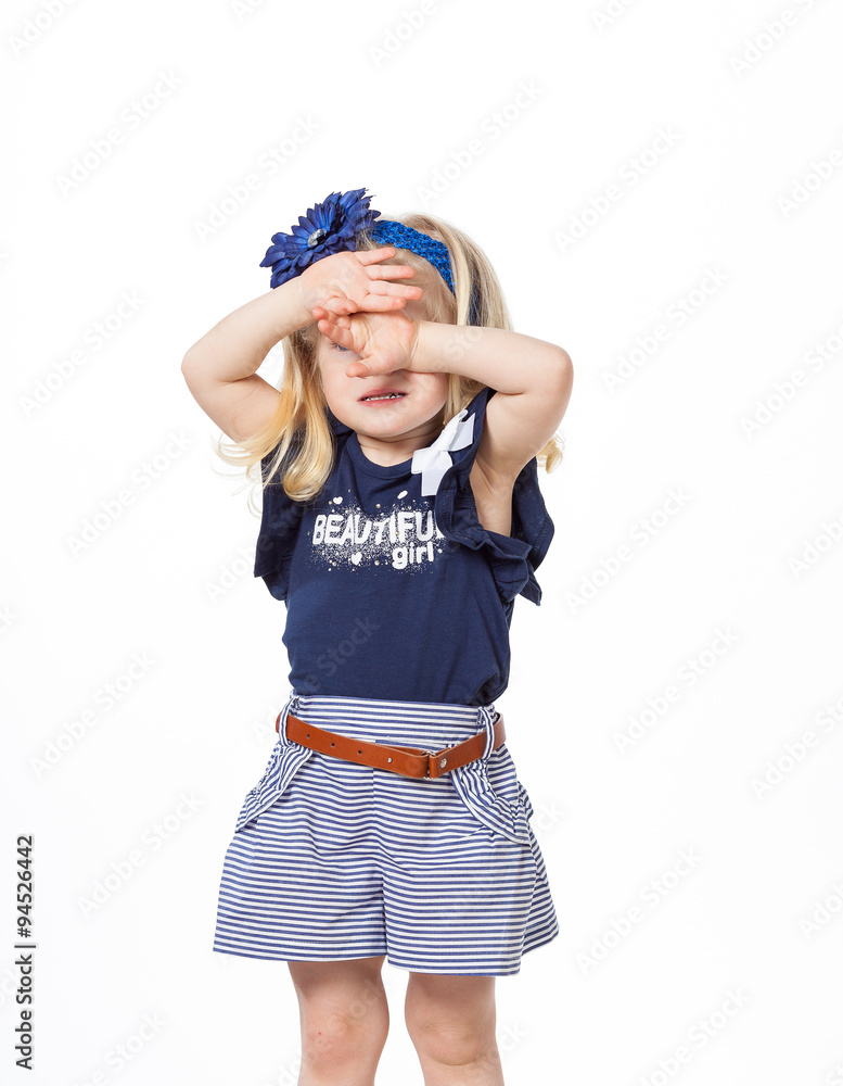 Little girl standing with her hands closing her face Little girl standing with her hands closing her face
