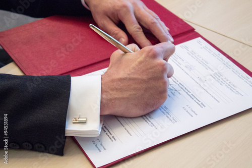 мужчина расписывается 