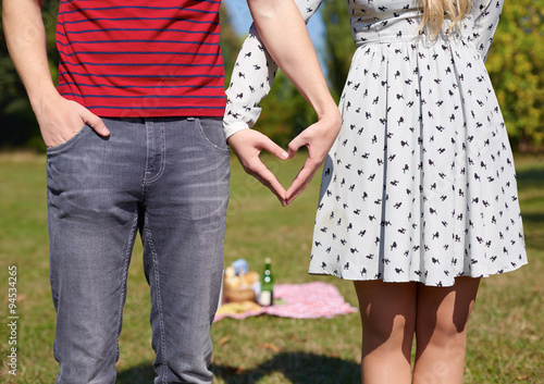 Beautiful Young Couple creating heart with hands, picnic, heart