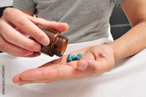 man in bed about to take some blue pills