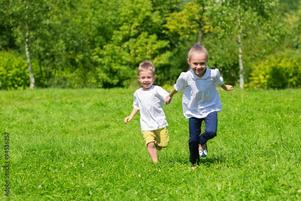 Girl and boy running on the grass