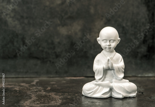 Praying buddha. White statue. Meditation concept. Vintage toned