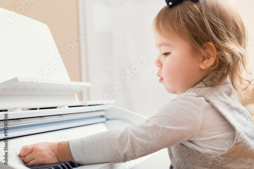 Little toddler girl playing piano