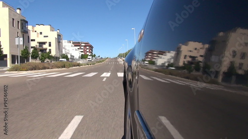 Wallpaper Mural side dark grey car driving on lonely asphalt urban road with painted white line lane in street with park trees in Madrid city Spain Europe
 Torontodigital.ca