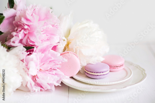 Macaroons on a plate in the flowers on a white background