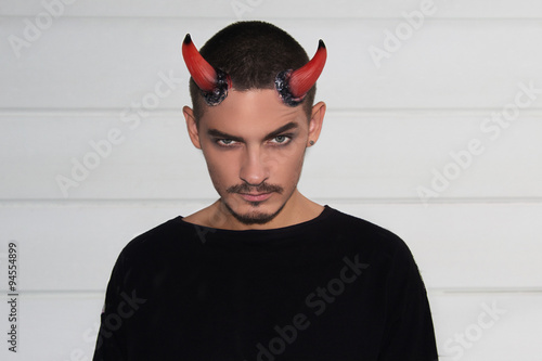 Handsome young man with Halloween horns on his head photo