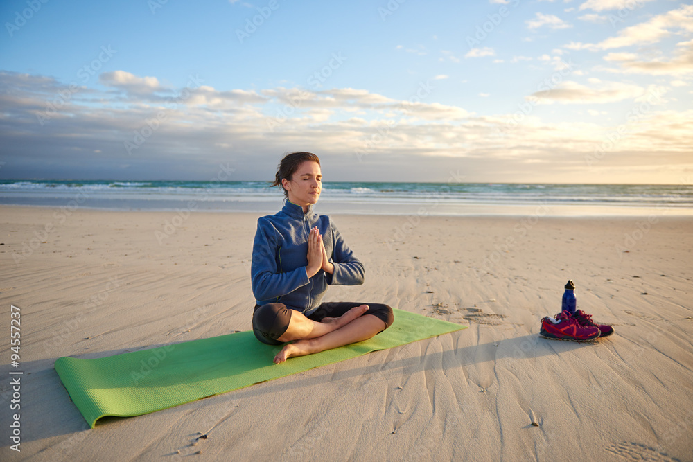 Fototapeta premium Peaceful woman meditating on the beach