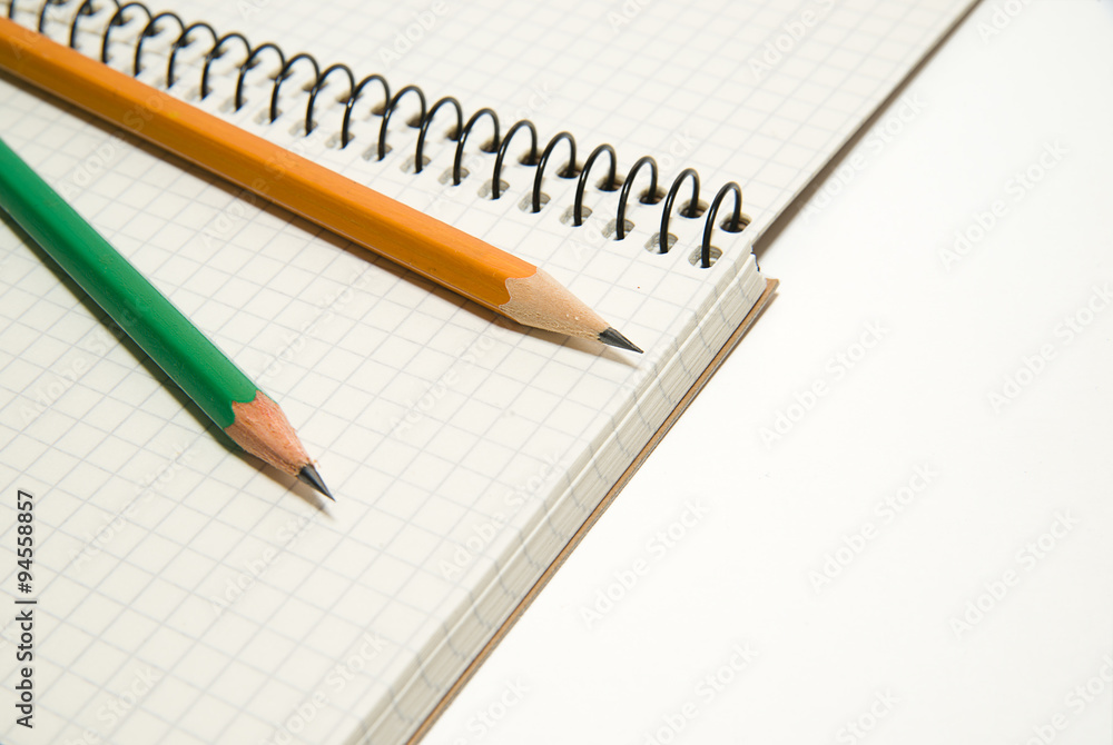 Opened notebook and pencils on over white Opened notebook and pencils on over white