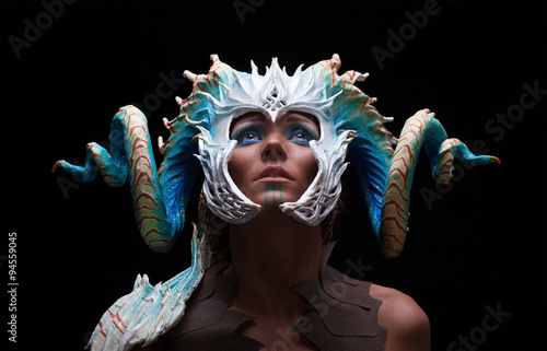 Fantasy concept of a young girl,strong brave warrior,wearing a helmet - mask with horns on head with corals with dots photo
