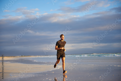 Fit man running on the beach in early morning