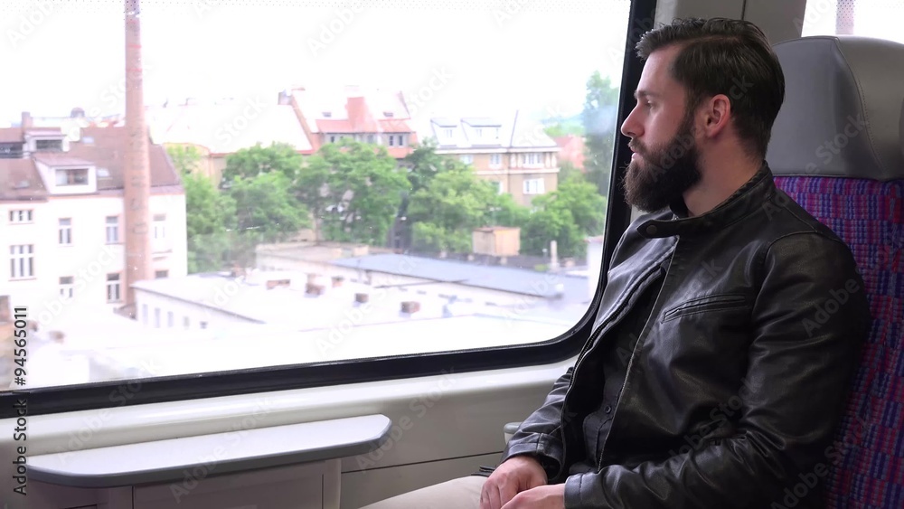 young handsome hipster man travel by train and looks out of the window - city young handsome hipster man travel by train and looks out of the window - city