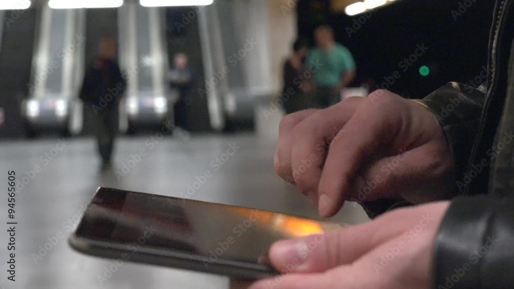 young handsome hipster man works on tablet - subway station (escalators) - closeup young handsome hipster man works on tablet - subway station (escalators) - closeup
