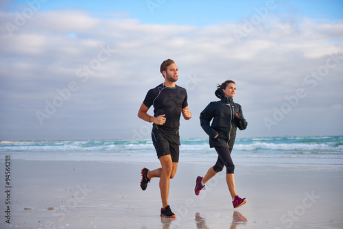 Man and woman enjoying a morning run on the beach