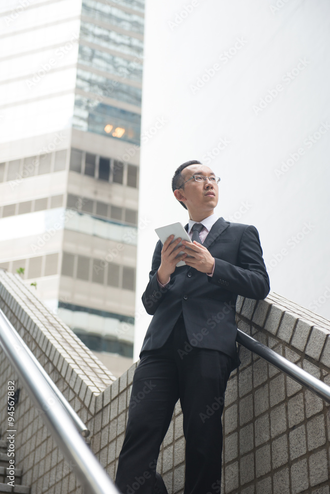 chinese businessman with tablet computer on hong kong central di chinese businessman with tablet computer on hong kong central di