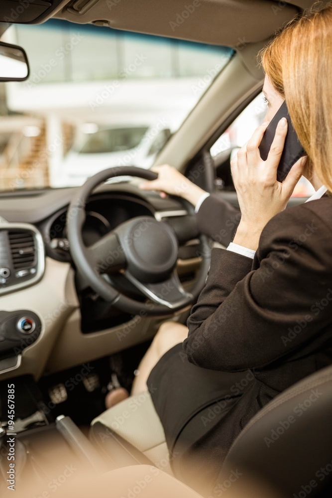 Naklejka premium Businesswoman having a phone call while siting in a car