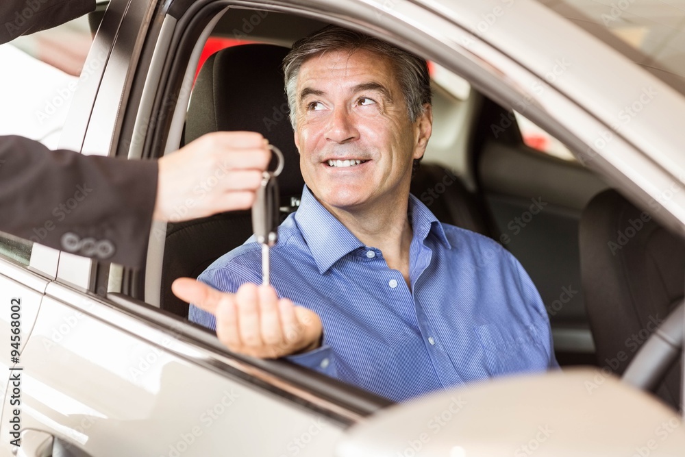 Salesman giving keys to a smiling businessman 