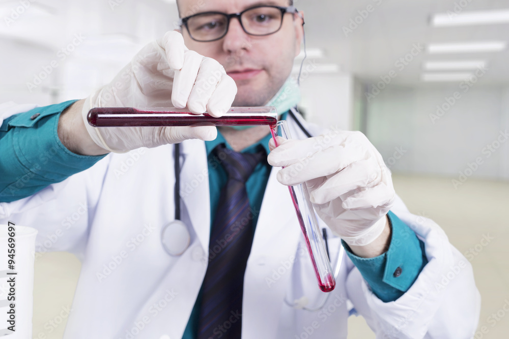 Scientist pouring blood in a laboratory Scientist pouring blood in a laboratory