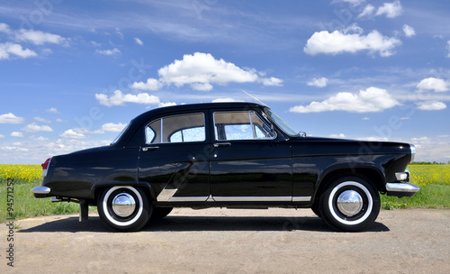 Retro car. Black old auto on sky background © savanno